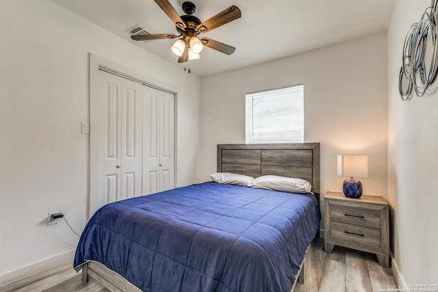 bedroom featuring baseboards, a closet, a ceiling fan, and light wood-style floors