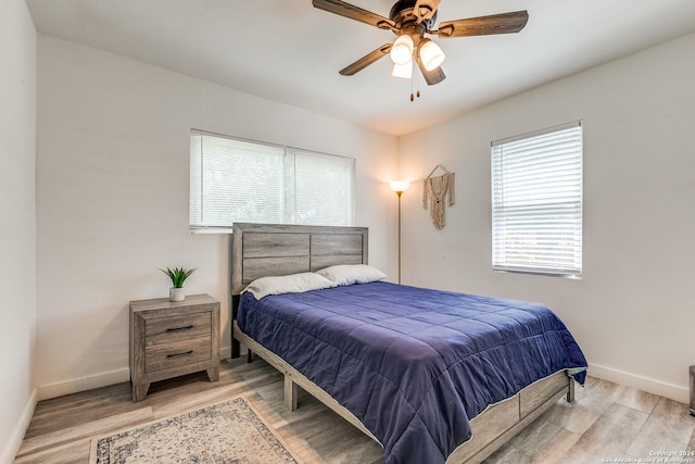 bedroom featuring wood finished floors, a ceiling fan, and baseboards