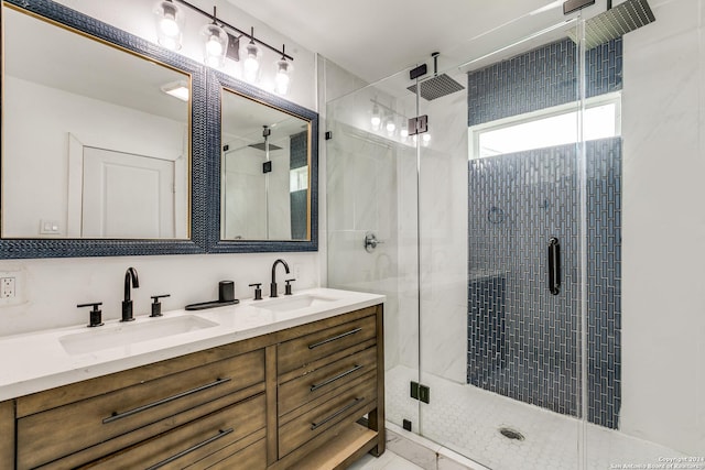 bathroom with double vanity, a stall shower, and a sink