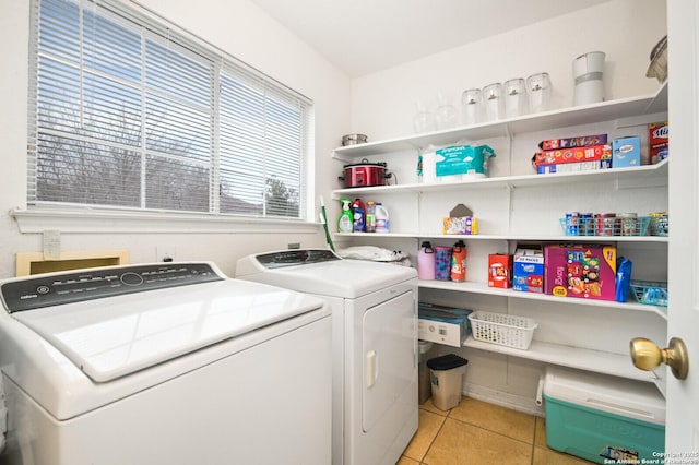 clothes washing area with laundry area, washer and clothes dryer, and light tile patterned floors