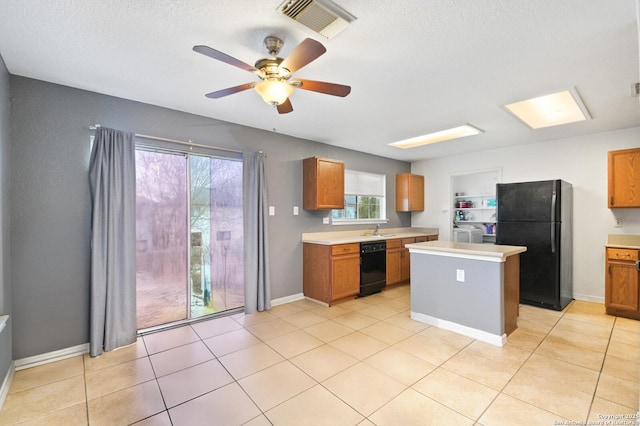 kitchen with black appliances, light countertops, a sink, and visible vents