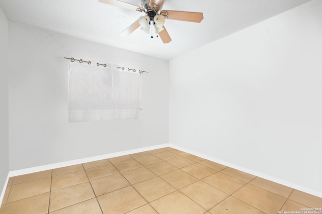 spare room with ceiling fan, light tile patterned flooring, and baseboards