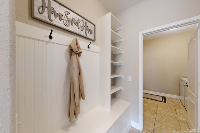 mudroom featuring washer / clothes dryer, light tile patterned flooring, and baseboards