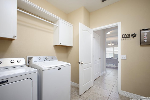 clothes washing area featuring washing machine and clothes dryer, cabinet space, visible vents, light tile patterned flooring, and baseboards