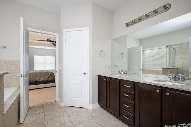 ensuite bathroom with ceiling fan, tile patterned flooring, a sink, double vanity, and a stall shower