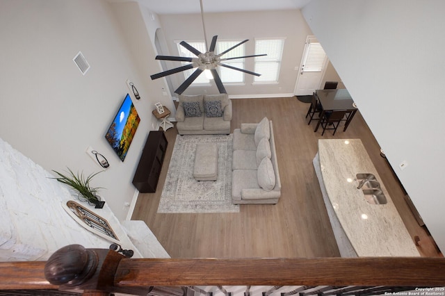 living room with wood finished floors, visible vents, and baseboards