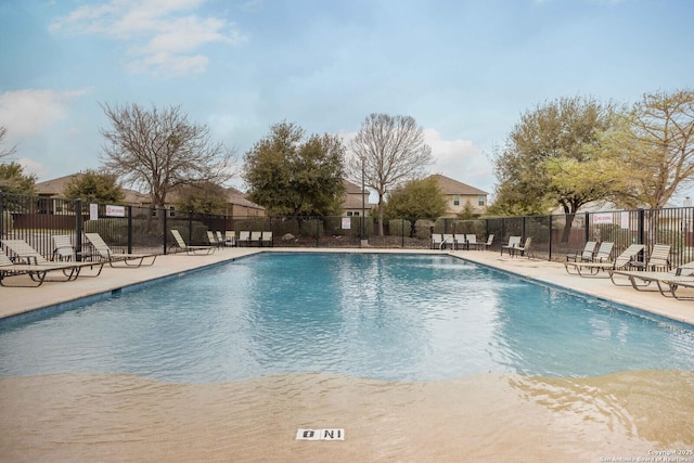 community pool with fence and a patio