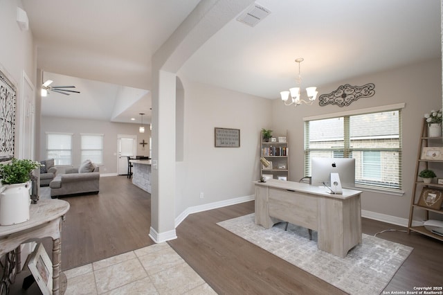 office area with baseboards, visible vents, arched walkways, and wood finished floors