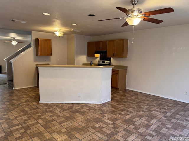 kitchen with brown cabinetry, recessed lighting, visible vents, and baseboards