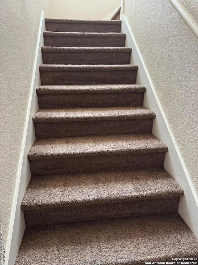 stairs featuring a textured wall