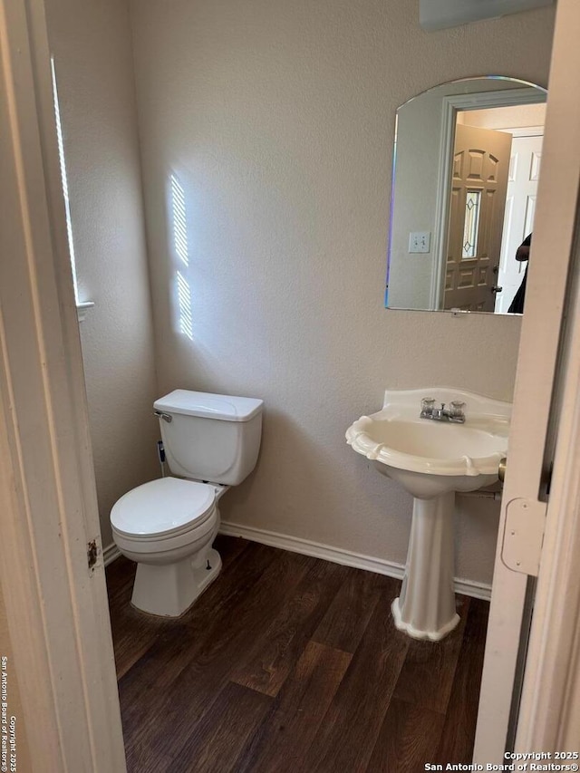 bathroom featuring baseboards, toilet, and wood finished floors