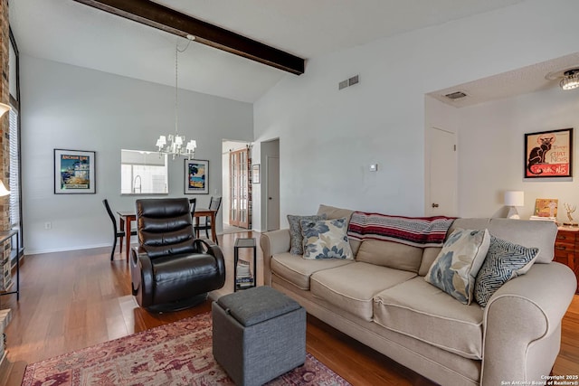 living room featuring wood finished floors, visible vents, baseboards, beam ceiling, and an inviting chandelier