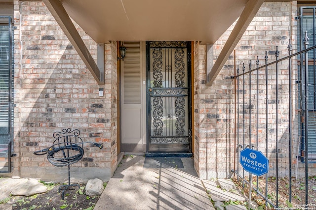 view of exterior entry with brick siding