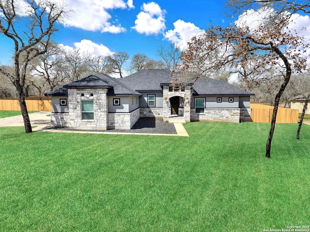 view of front of house with a front yard, fence, and stucco siding