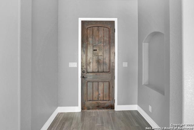 foyer featuring baseboards and wood finished floors