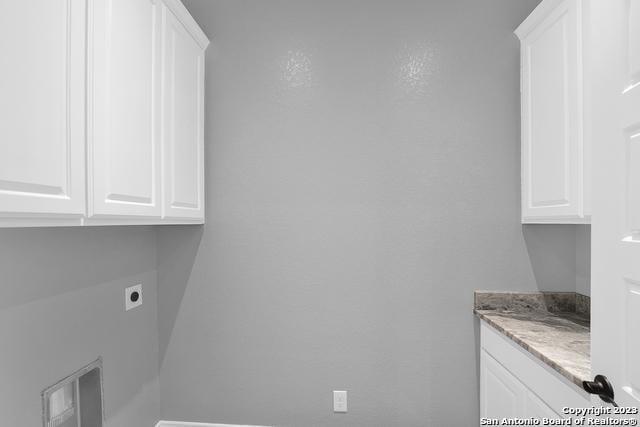 laundry area featuring hookup for an electric dryer and cabinet space