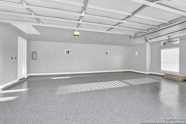 garage with baseboards and a garage door opener