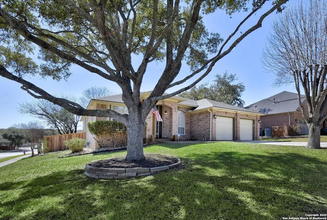 view of front of home with an attached garage, a front yard, fence, and brick siding