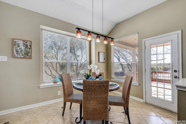 dining space featuring lofted ceiling, light tile patterned floors, and baseboards