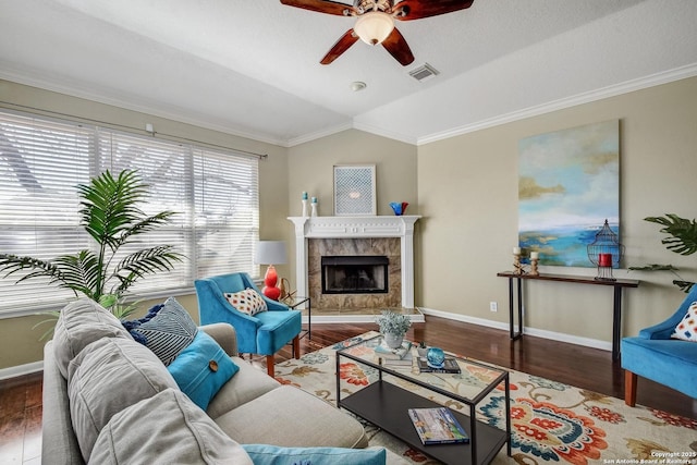 living area with ceiling fan, a premium fireplace, wood finished floors, baseboards, and vaulted ceiling