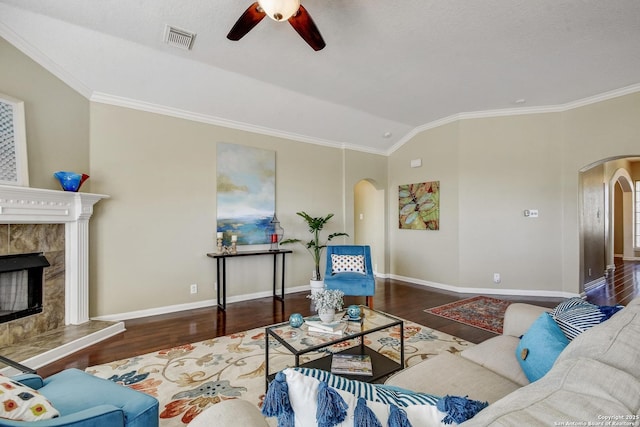 living room with arched walkways, visible vents, a premium fireplace, wood finished floors, and baseboards