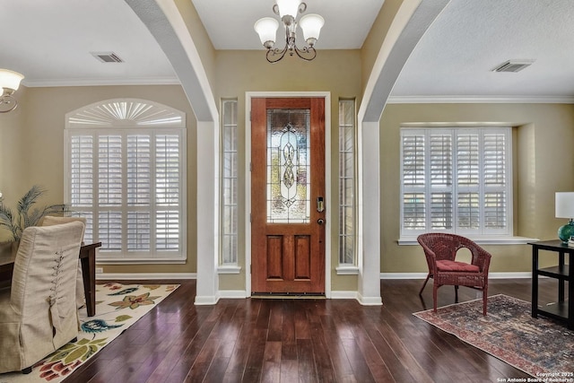 entryway with a chandelier, baseboards, visible vents, and hardwood / wood-style floors