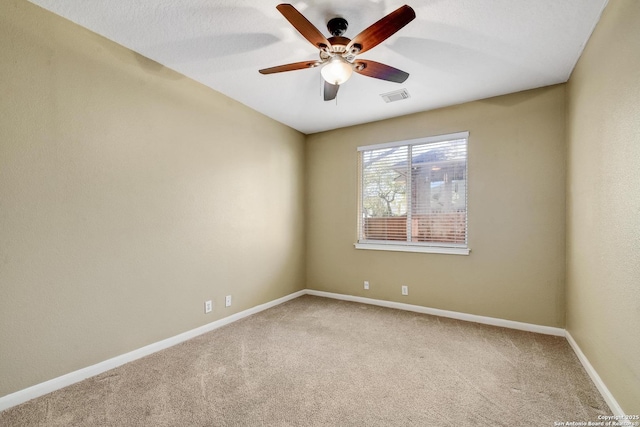 spare room with ceiling fan, carpet flooring, visible vents, and baseboards