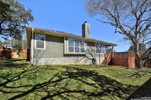 rear view of property featuring a deck, fence, stairway, a lawn, and a chimney