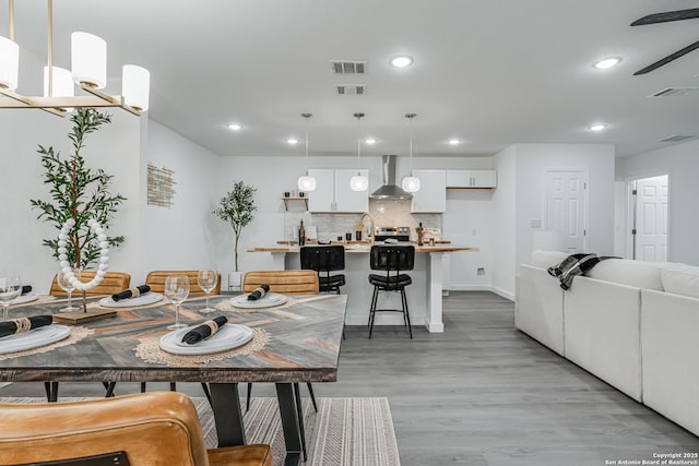 dining room featuring light wood-type flooring, visible vents, and recessed lighting