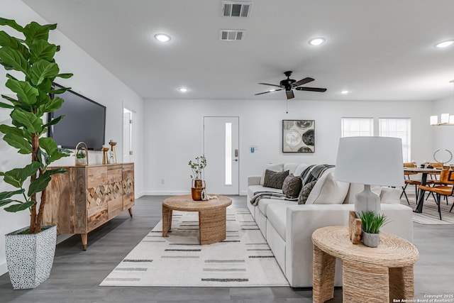 living area with recessed lighting, visible vents, ceiling fan, and wood finished floors