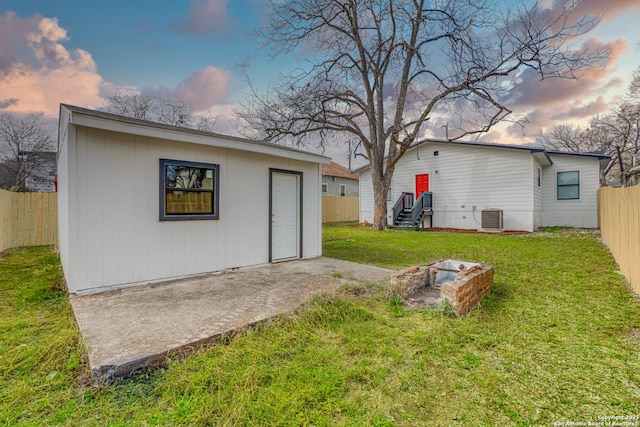 view of yard featuring an outbuilding, a fenced backyard, cooling unit, and entry steps