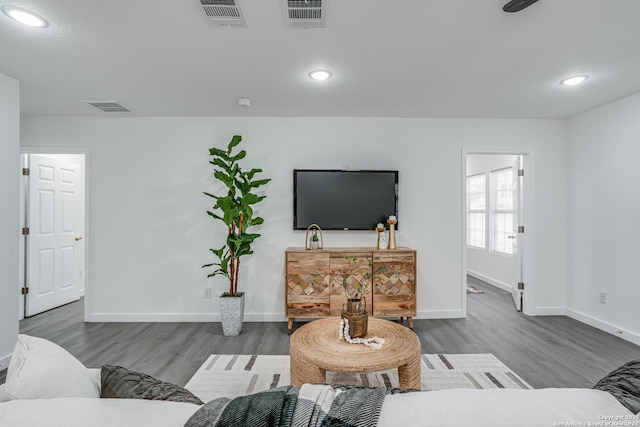 living area with visible vents, baseboards, and wood finished floors