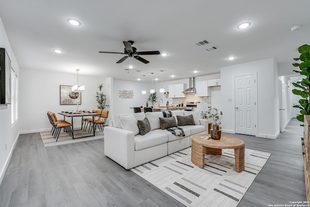 living area featuring a ceiling fan, recessed lighting, visible vents, and light wood-style flooring