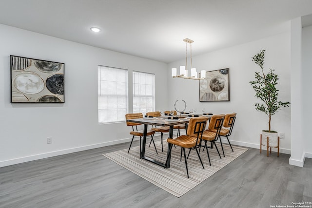 dining space with a chandelier, recessed lighting, wood finished floors, and baseboards