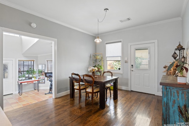 dining space featuring baseboards, ornamental molding, and wood finished floors