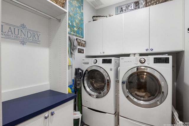 laundry room featuring visible vents, separate washer and dryer, and cabinet space