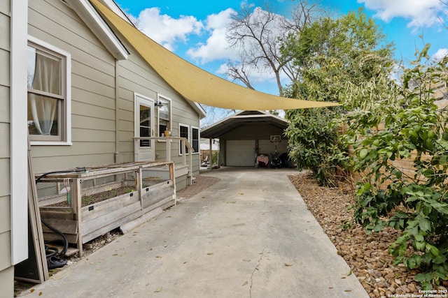 view of home's exterior featuring a garage, a vegetable garden, and an outdoor structure