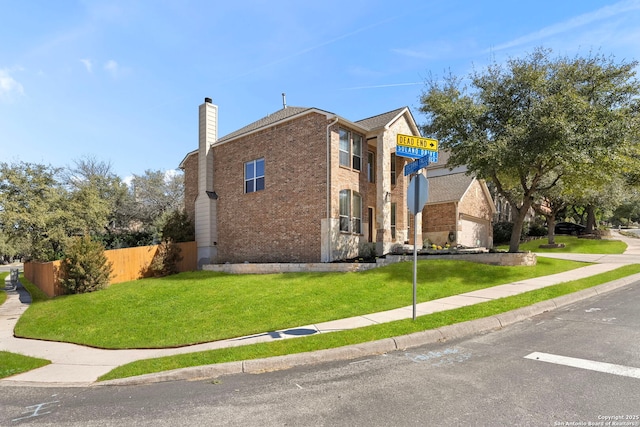 view of side of home featuring brick siding, fence, a chimney, and a lawn