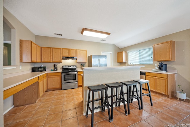 kitchen with light tile patterned floors, lofted ceiling, visible vents, appliances with stainless steel finishes, and under cabinet range hood