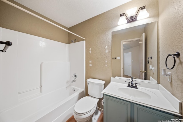 full bathroom with toilet, vanity, tub / shower combination, and a textured wall