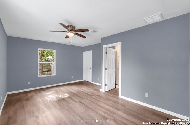 unfurnished bedroom with baseboards, visible vents, ceiling fan, and wood finished floors