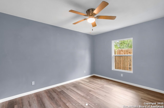 spare room with a ceiling fan, baseboards, and wood finished floors