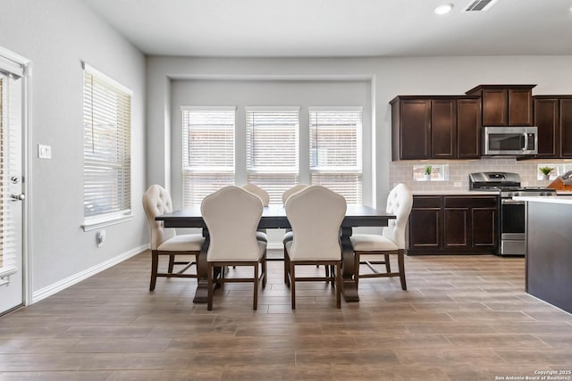 dining space with baseboards and wood finished floors