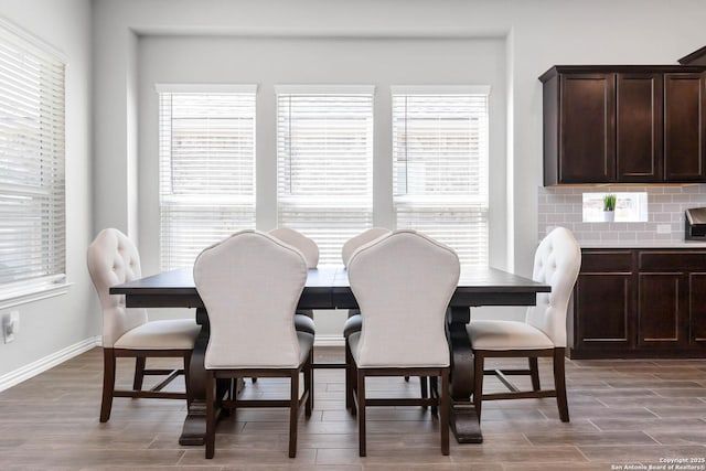 dining space with wood finished floors, a wealth of natural light, and baseboards