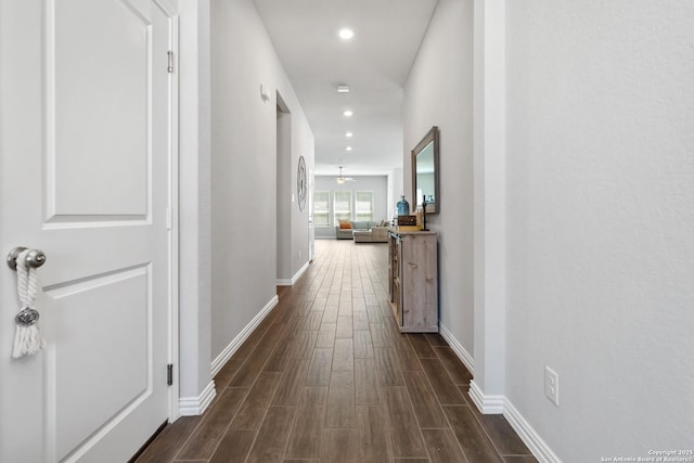 corridor featuring wood finish floors, baseboards, and recessed lighting