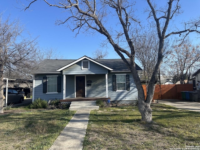 bungalow-style home with fence, a porch, and a front yard