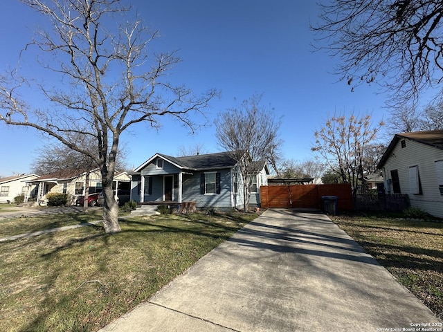 bungalow-style house with driveway, a front lawn, and fence