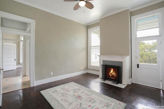 living area featuring plenty of natural light, baseboards, and crown molding