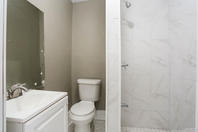 bathroom with tiled shower, vanity, and toilet