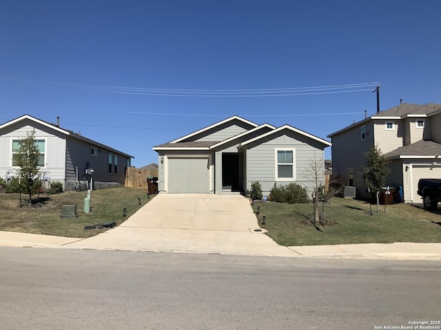 view of front of house featuring a garage, fence, concrete driveway, board and batten siding, and a front yard